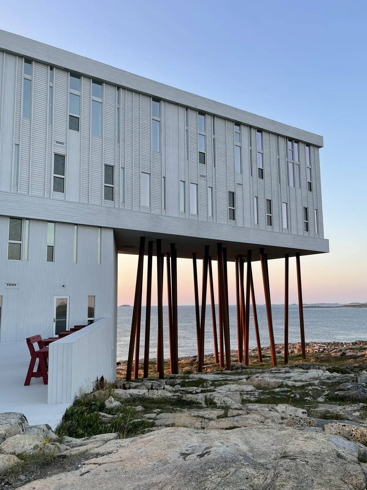Fogo Island Inn on its stilts above the rocky shoreline at dusk